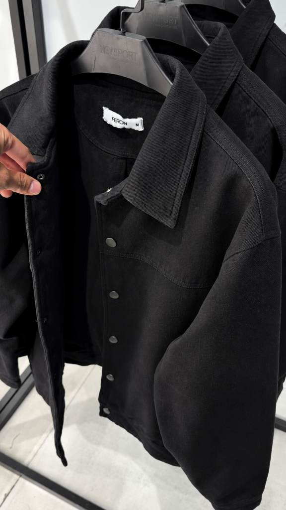 A black snap-button overshirt jacket with a spread collar