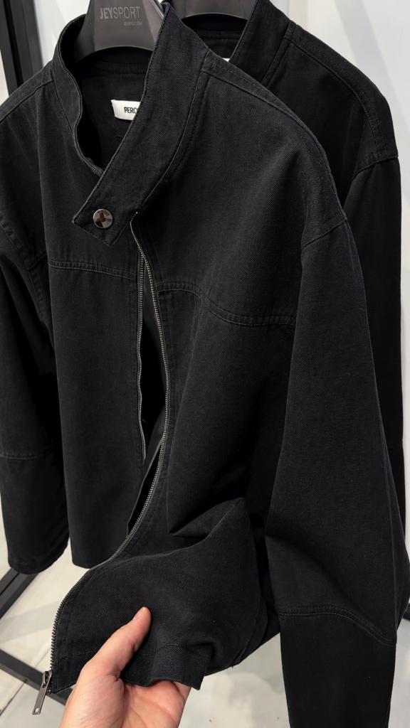 A black washed cotton jacket with a band collar and zip