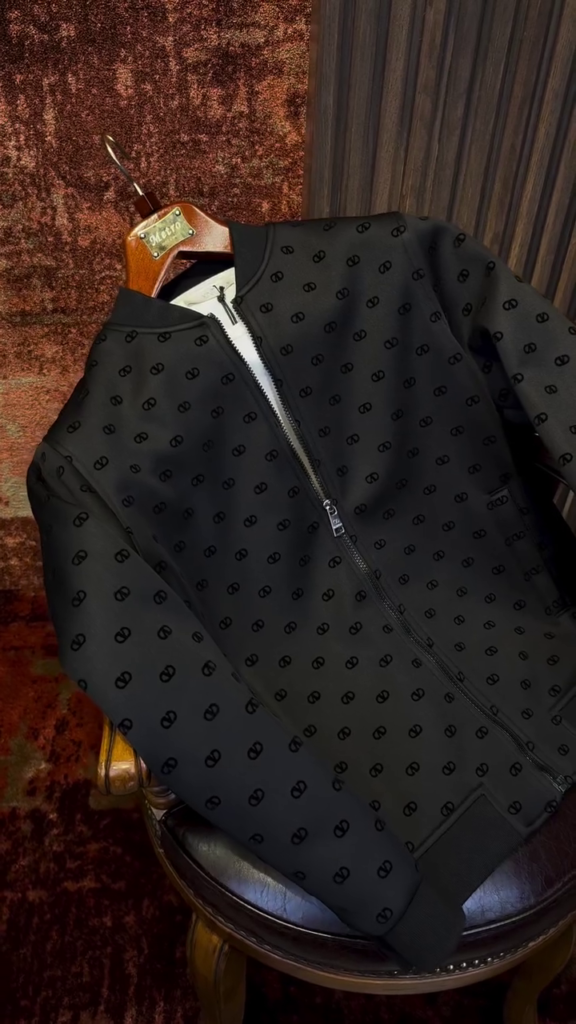 A black bomber jacket with a tonal all-over pattern